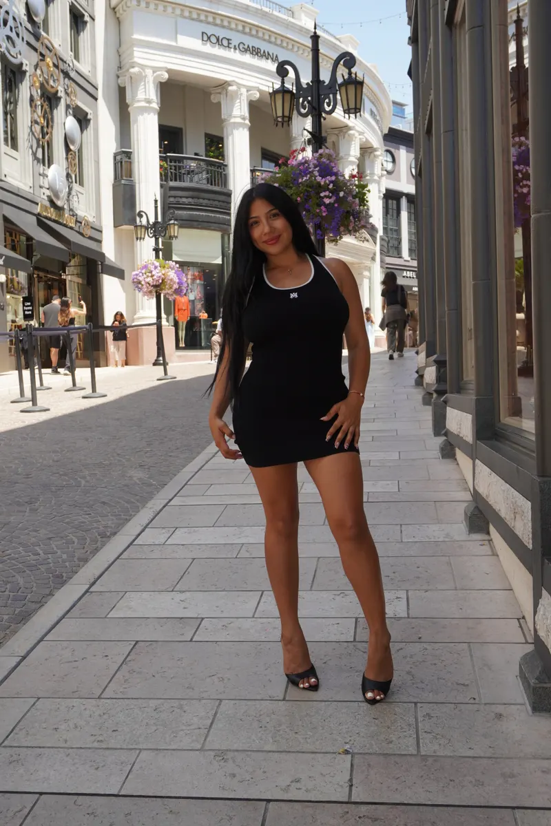 Alessandra Cruz in a black dress on a shopping street