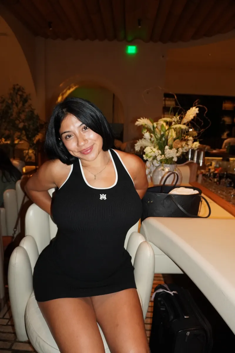 Alessandra Cruz smiling, seated in a black dress